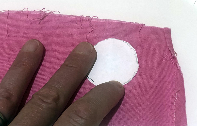 Using a pattern to cut out fabric to cover buttons
