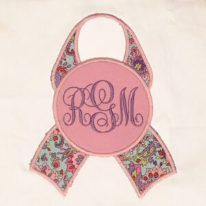 Pink breast cancer awareness ribbon with blank circle for adding an initial or a monogram.