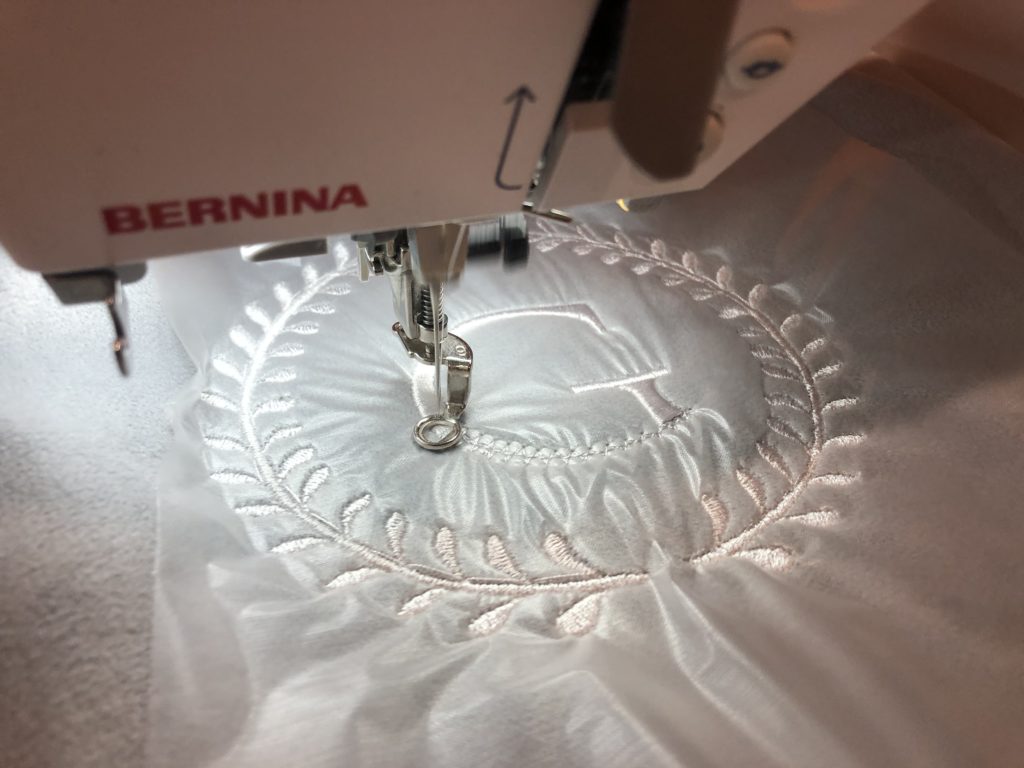 stitching out the monogram.