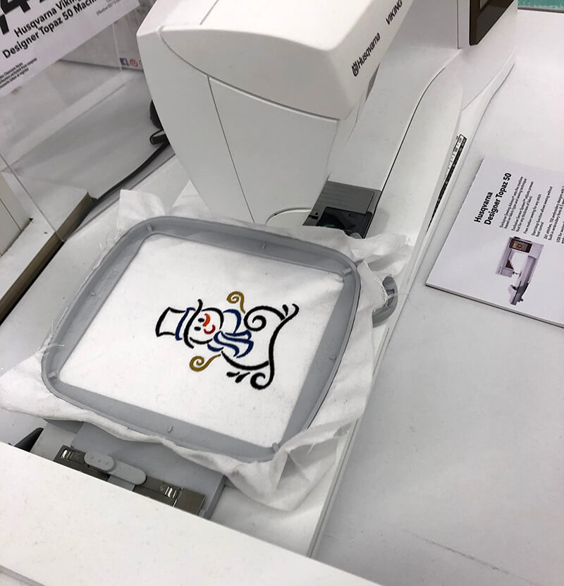An embroidery machine stitching out a snowman design