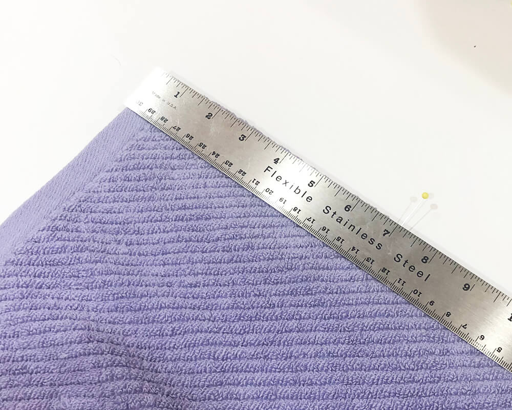 marking the center of the design on the wrong side of the towel