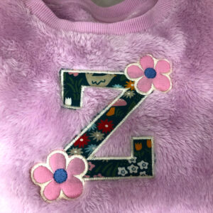 Whimsical single lowercase letter with flowers appliqué