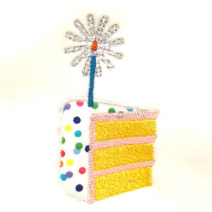 Slice of cake with single candle appliqué design