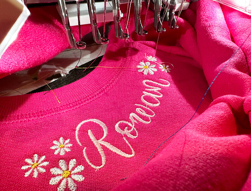 stitching out the embroidery around the neckline